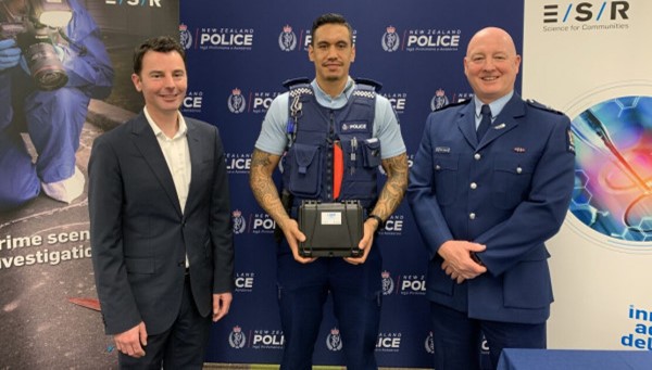 Mr Dion Sheppard (left) and Acting Assistant Commissioner: Investigations Mike Johnson (right) stand with Constable Wepiha Te Kanawa (centre) who is holding the Lumi™ Drug Scan device.